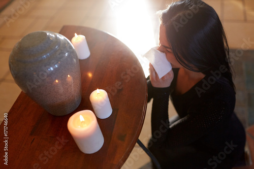 woman with cremation urn at funeral in church