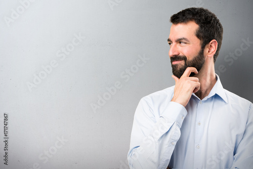 Handsome man with beard looking lateral on textured background