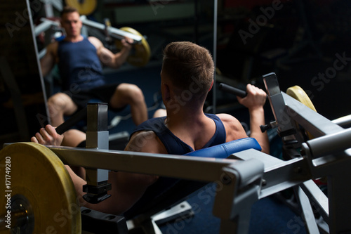man doing chest press on exercise machine in gym