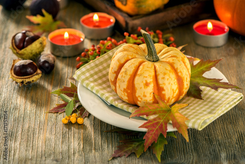 Autumn table setting with pumpkings and candles, fall home decoration for festive dinner