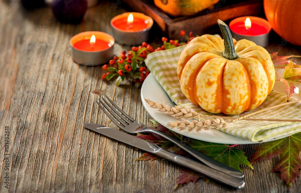 Autumn table setting with pumpkings and candles, fall home decoration for festive dinner