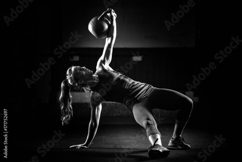 Woman athlete exercising with kettlebell photo