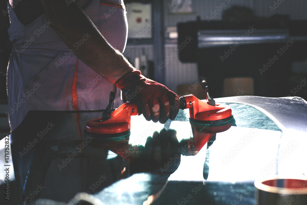 Senior man in workshop. Mechanic changing glass in his workshop. Close up. Senior man in workshop. Mechanic changing glass in his workshop. Close up.