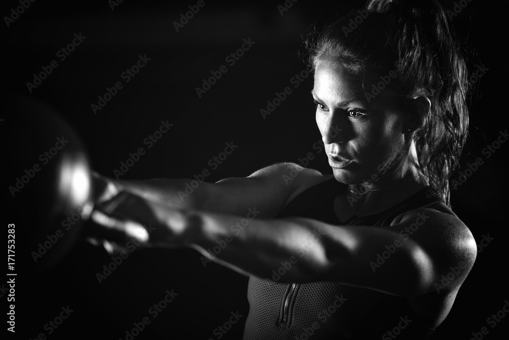 Woman athlete exercising with kettlebell Woman athlete exercising with kettlebell
