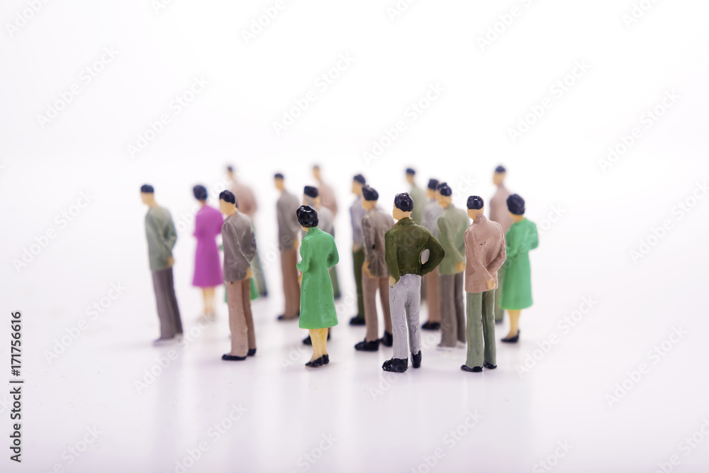Group of miniature people over white background.