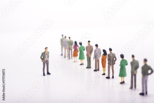 Group of miniature people over white background.