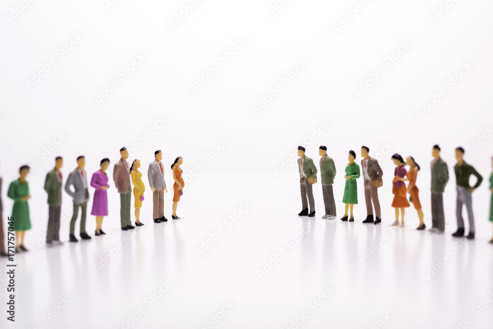 Miniature people in two lines across to each other over white background. Miniature people in two lines across to each other over white background.