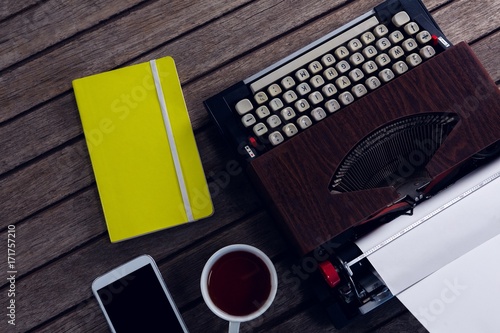 Vintage typewriter, diary, black coffee and smart phone on