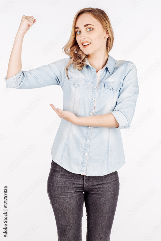 young woman in jeans shirt shows with your finger the muscles in the hand. Image Isolated on white background young woman in jeans shirt shows with your finger the muscles in the hand. Image Isolated on white background
