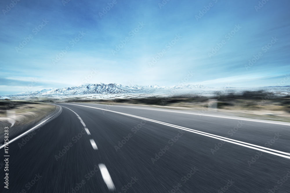 empty asphalt road with snow mountains in blue sky