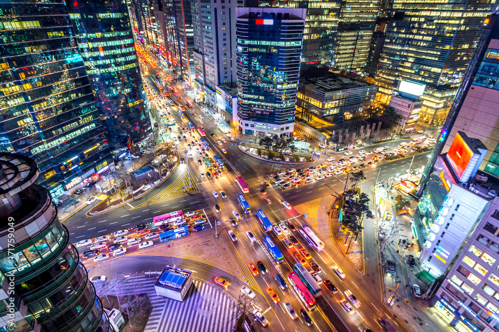 Fototapeta Traffic speeds through an intersection at night in Gangnam, Seoul in South Korea.