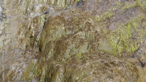 Big beautiful waterfall flows down the rocks mountains. photo