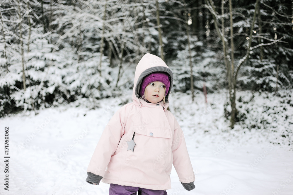 Cute three years old girl walking in the snow