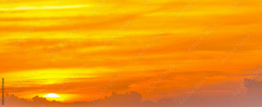 Naklejka premium Orange sky with clouds at dusk