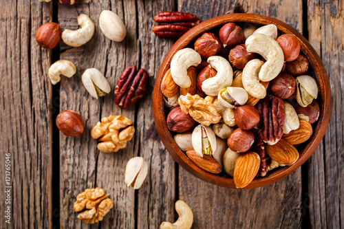 Nuts Mixed in a wooden plate.Assortment, Walnuts,Pecan,Almonds,Hazelnuts,Cashews,Pistachios.Concept of Healthy Eating.Vegetarian.selective focus. photo