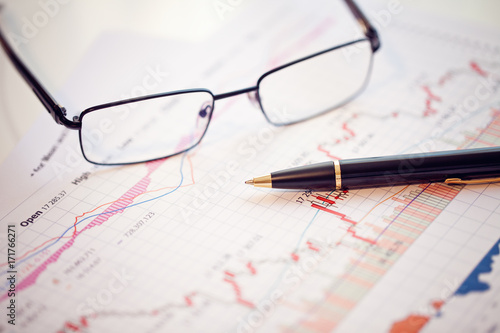 Pen and glasses on financial chart business concept analysis of sales plan business report business work station with paperwork