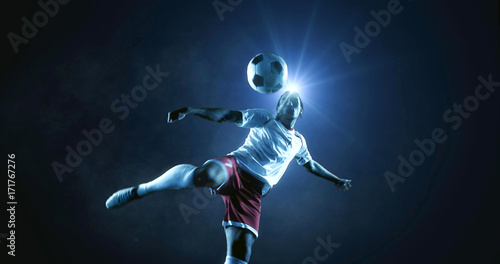 Soccer player kicks the ball on the soccer stadium. He wear unbranded sports clothes. Stadium and crowd made in 3D. © haizon