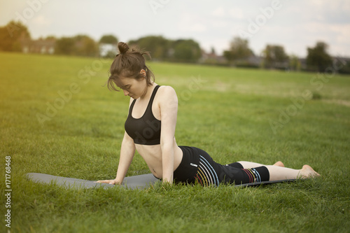 Young girl doing yoga and stretching lower back © Dawid
