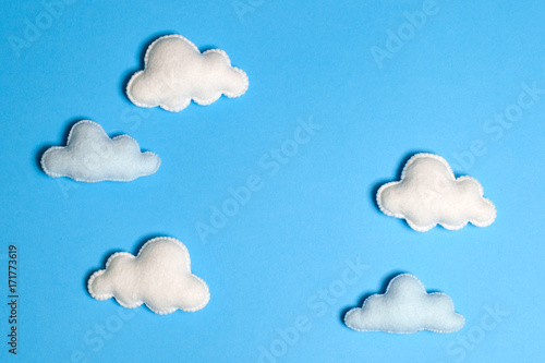 Craft white clouds in blue sky with frame, copyspace. Hand made felt toys. Abstract sky.