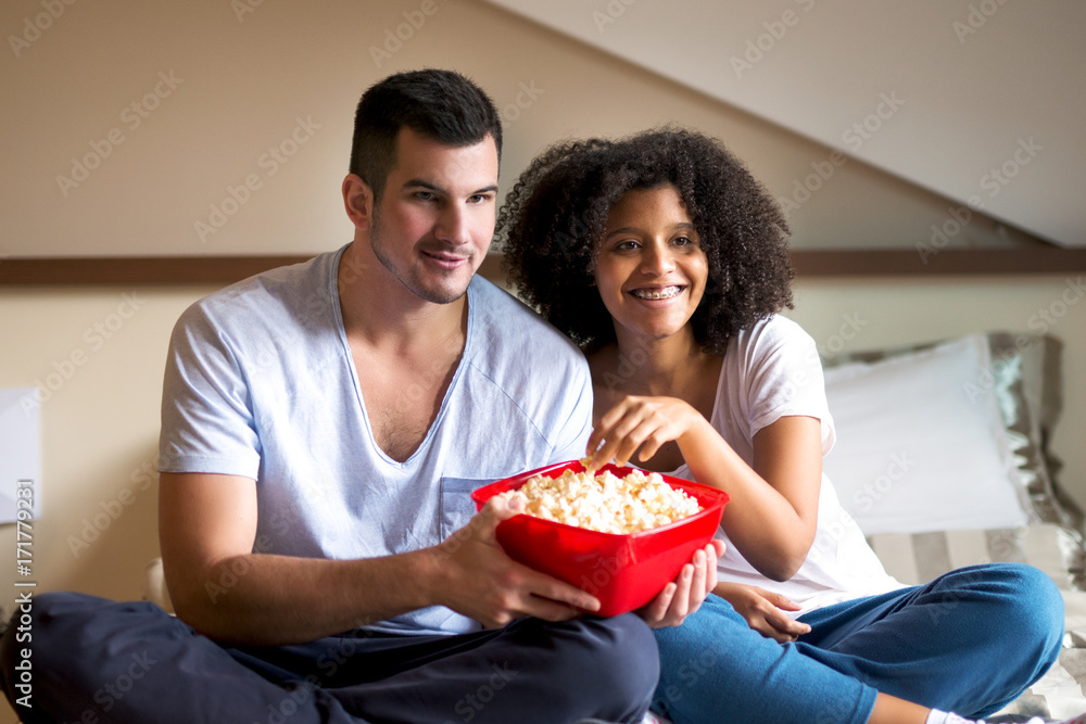 Young charming couple is having a great time with popcorn and movie. Young charming couple is having a great time with popcorn and movie.