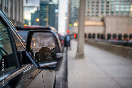 Reflection in the mirror of black Suv of city skyline 