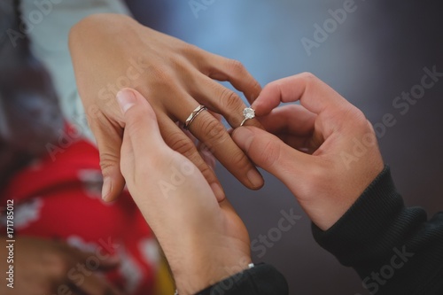 Cropped hand of man putting ring on woman finger