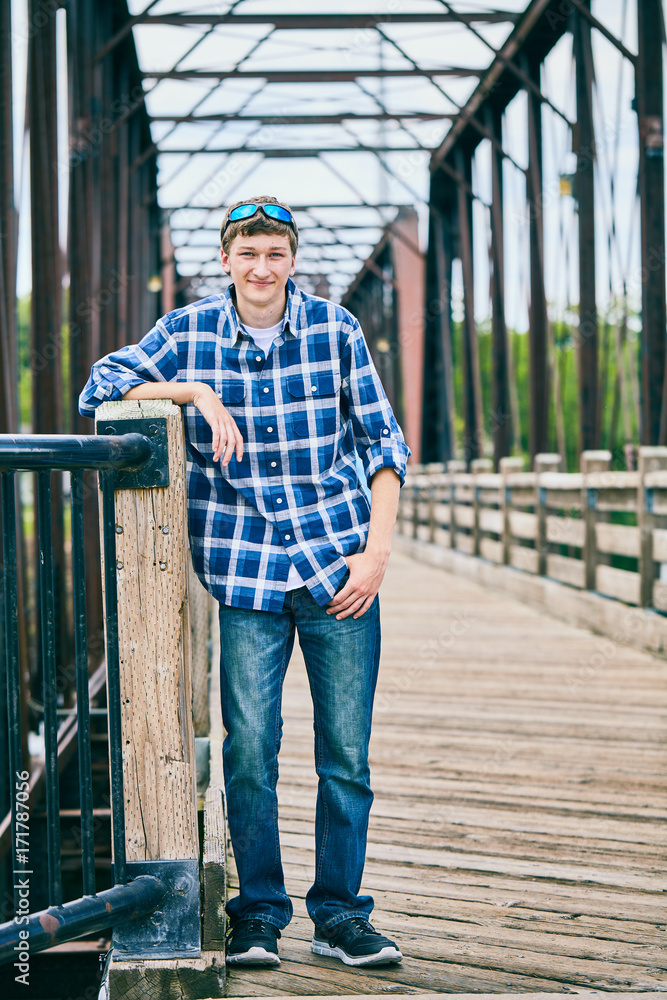 Portrait of happy young man standing on bridge