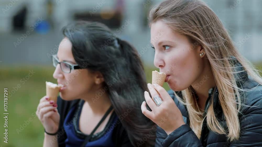 Two girls eat ice cream on a sunny day - slow motion Two girls eat ice cream on a sunny day - slow motion