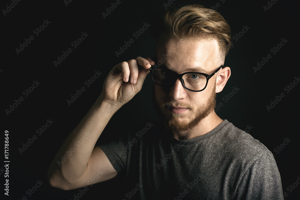 portrait of young man above black background portrait of young man above black background