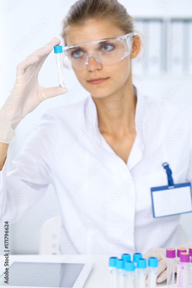 Female scientific researcher in laboratory studying substances or blood sample. Medicine and science concept Female scientific researcher in laboratory studying substances or blood sample. Medicine and science concept