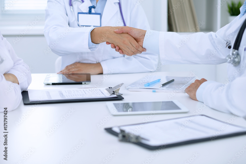 Doctors shaking hands to each other finishing up medical meeting Doctors shaking hands to each other finishing up medical meeting
