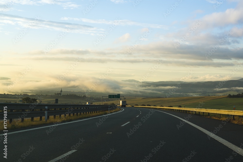 Fototapeta premium Misty morning sunrise on the road. Slovakia