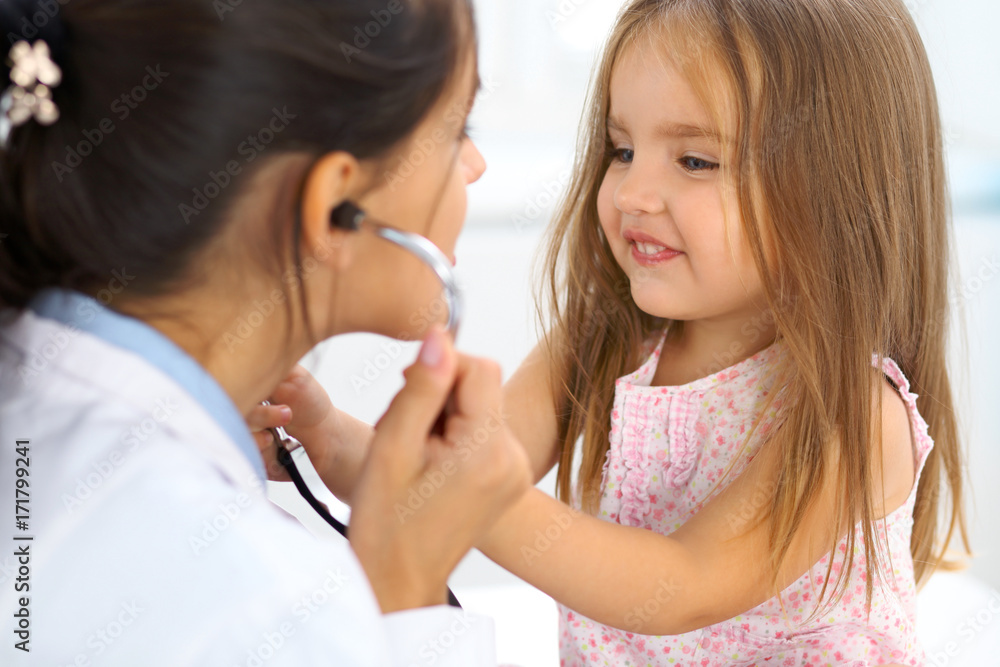 Happy little girl at health exam at doctor office. Medicine and health care concept Happy little girl at health exam at doctor office. Medicine and health care concept