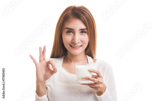 Healthy Asian woman drinking a glass of milk show OK sign.