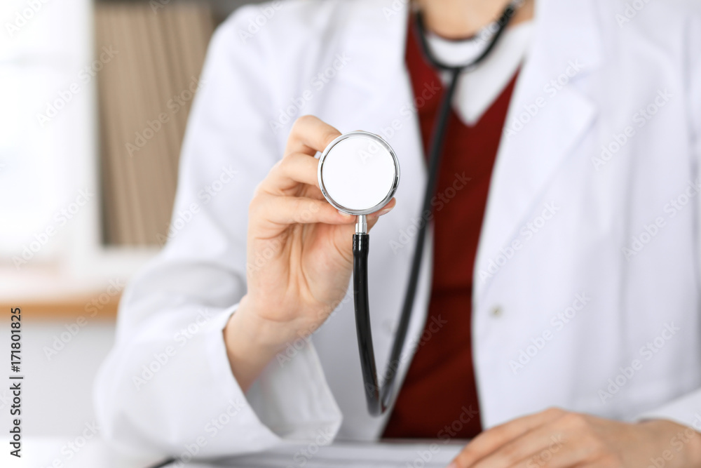 Unknown female doctor with a stethoscope in the hands. Physician is redy to exemine a patient Unknown female doctor with a stethoscope in the hands. Physician is redy to exemine a patient