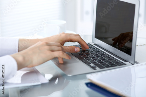 Close up of business woman hands typing on laptop computer