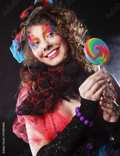 woman with creative make-up in doll style with candy. photo