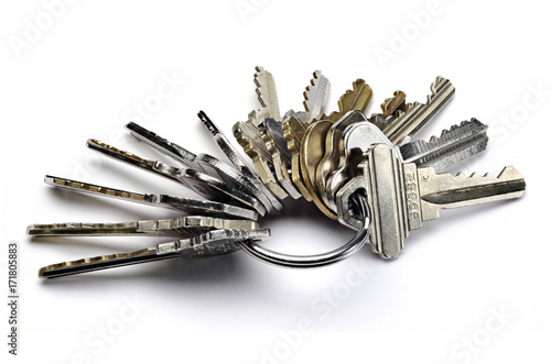 Close up of metal key ring with many worn keys isolated on white