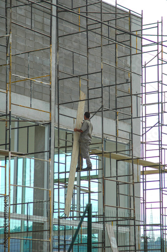construction worker on scaffolding without harness or protective gear