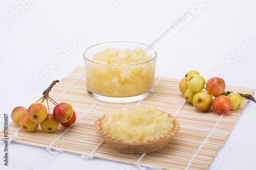Still life. cake with apple jam, vase with jam and bunches of small apples on white background