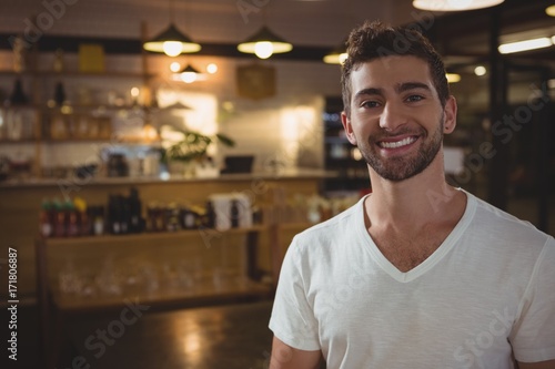 Portrait of smiling waiter in cafe