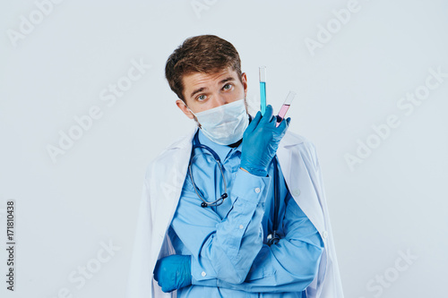 1462255 a man is holding a laboratory glassware in a medical mask