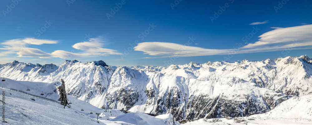 Fototapeta premium Panoramic landscape of ski resort valley with amazing beatiful mountains and dramatic cloudy sky on the background in Austria, Tyrol