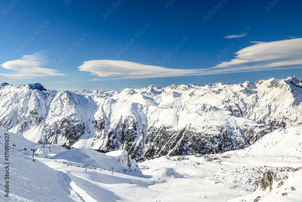 Panoramic landscape of ski resort valley with amazing beatiful mountains and dramatic cloudy sky on the background in Austria