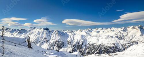 Panoramic landscape of ski resort valley with amazing beatiful mountains and dramatic cloudy sky on the background in Austria, Tyrol