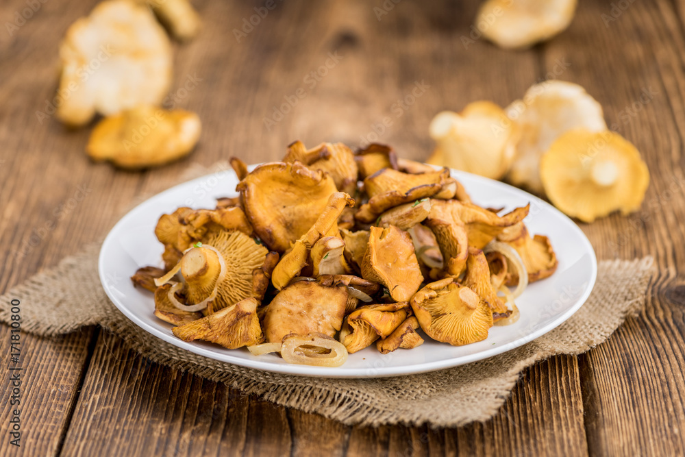 Fried Chanterelles on wooden background; selective focus