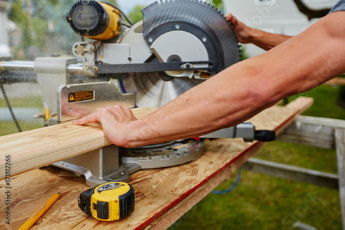 Man using saw to cut wood