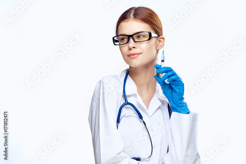 1477972 Young beautiful woman on white isolated background with glasses, doctor holding a syringe