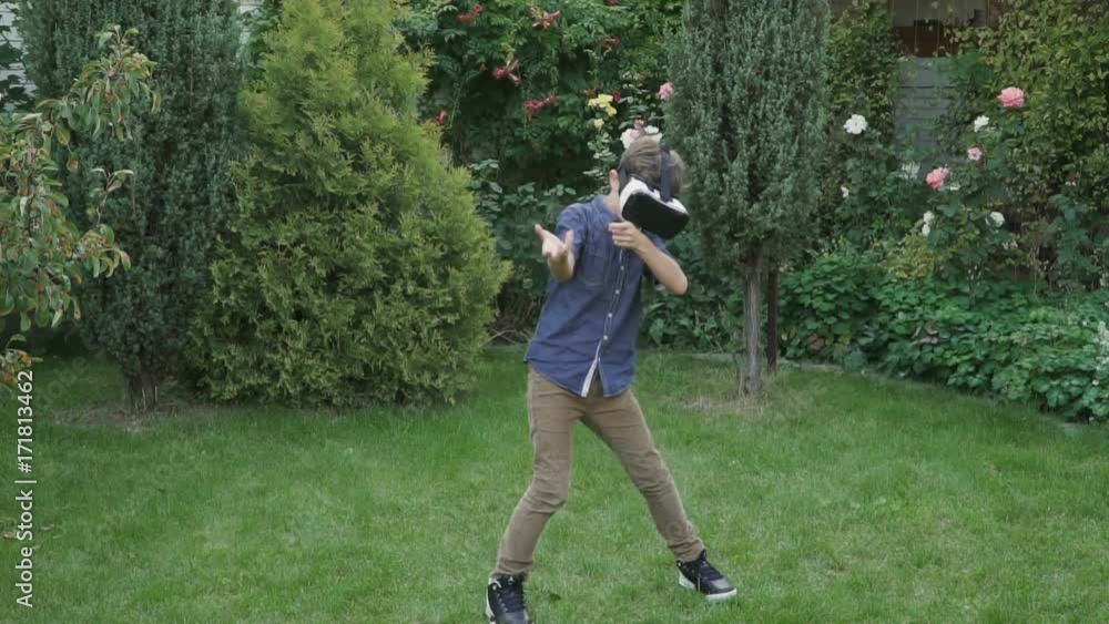 Little boy in virtual reality glasses shoots in invisible opponent Little boy in virtual reality glasses shoots in invisible opponent