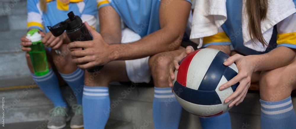 Mid section of sports team holding volleyball Mid section of sports team holding volleyball